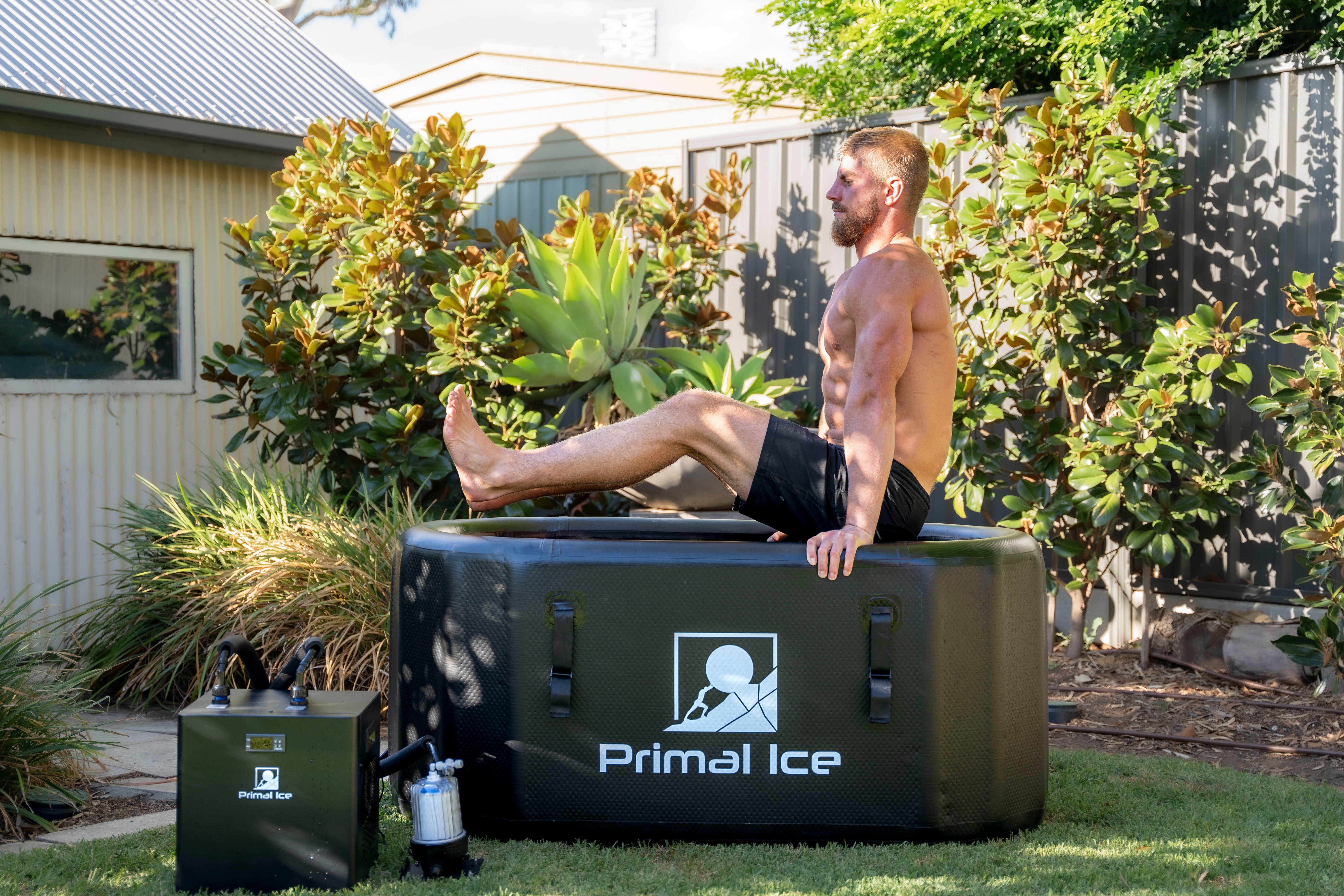 man holding himself above ice bath tub and chiller unit