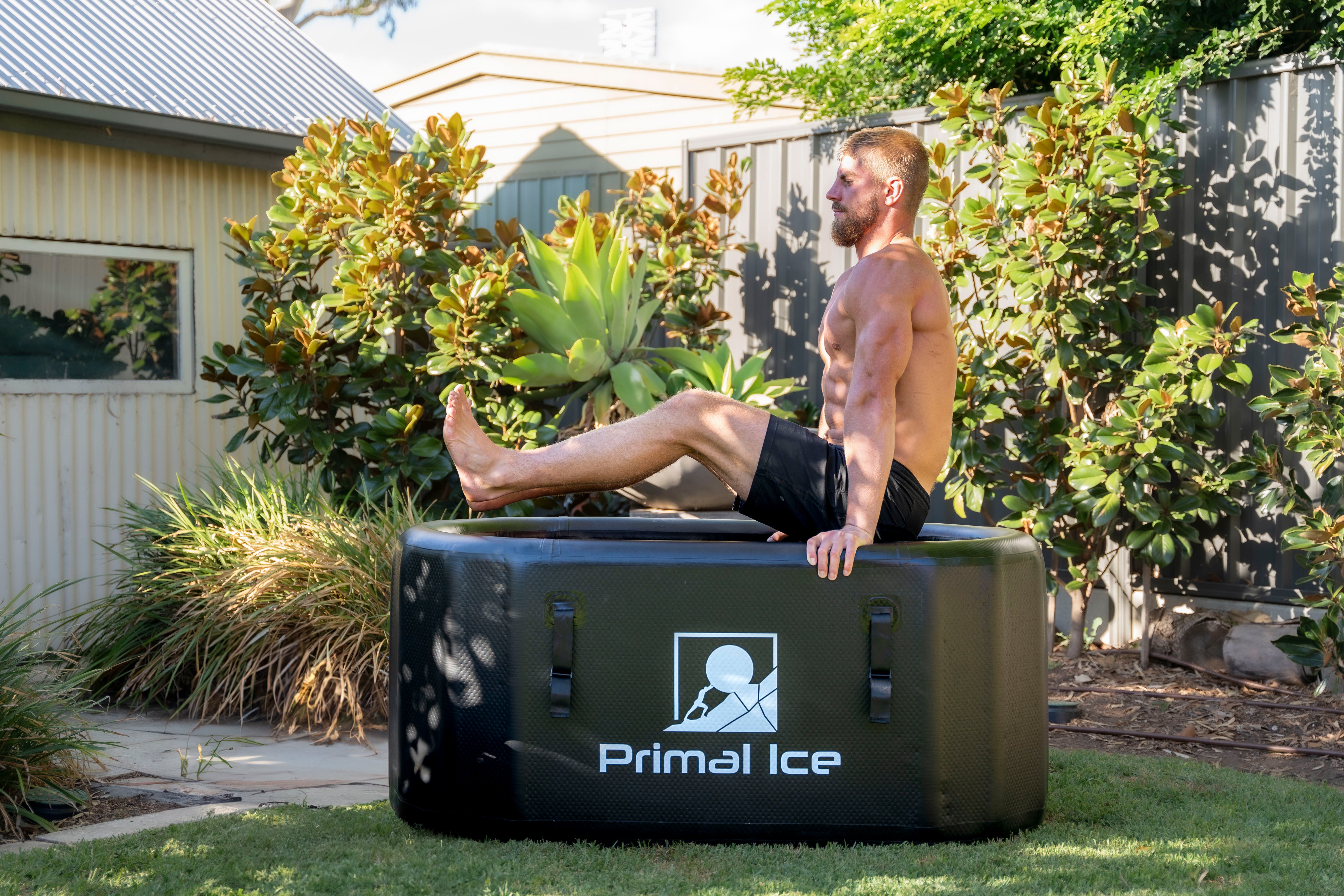 man holding himself above ice bath tub